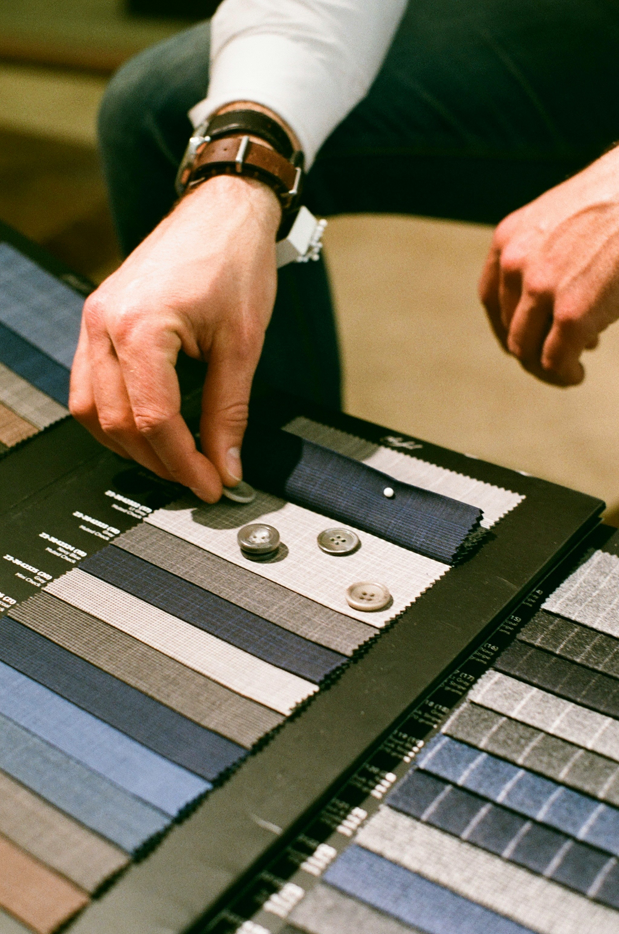 Cloth swatches and buttons being considered for a client.